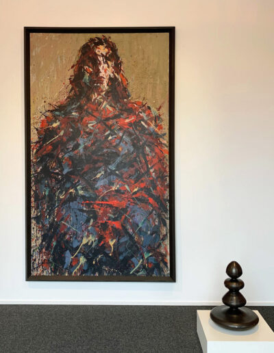 Ein abstrahiertes Gemälde von Max Uhlig. Dame mit rotem Schal. Daneben eine Skulptur von Abraham David Christian.