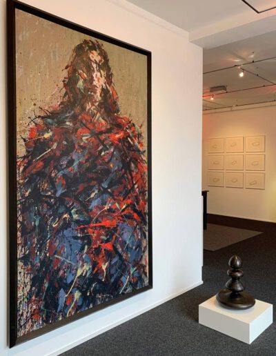 Ein abstrahiertes Gemälde von Max Uhlig. Dame mit rotem Schal. Daneben eine Skulptur von Abraham David Christian.