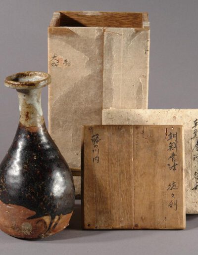 Eine japanische Sakeflasche tokkuri aus chosen-karatsu-Keramik. Hier mit der dazugehörigen Holzdose.