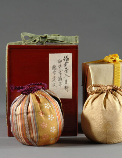Eine Teedose chaire des Künstlers Fujiwara Ken aus Bizen-Keramik. Hier mit der dazugehörigen Dose und ihrer Beschriftung sowie den Stoffbeuteln.