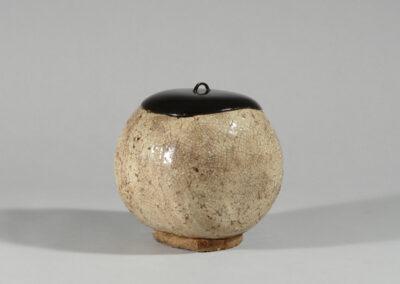 Ein Frischwassergefäß mizusashi aus Hagi-Keramik mit schwarzem Lackdeckel.