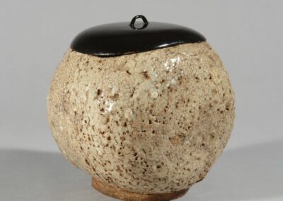 Ein Frischwassergefäß mizusashi aus Hagi-Keramik mit schwarzem Lackdeckel.