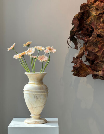 Eine klassizistische Vase aus Marmor. Hier mit Blumen in der Galerie fotografiert. Rechts ein Teil einer Skulptur von Bernard Schultze.